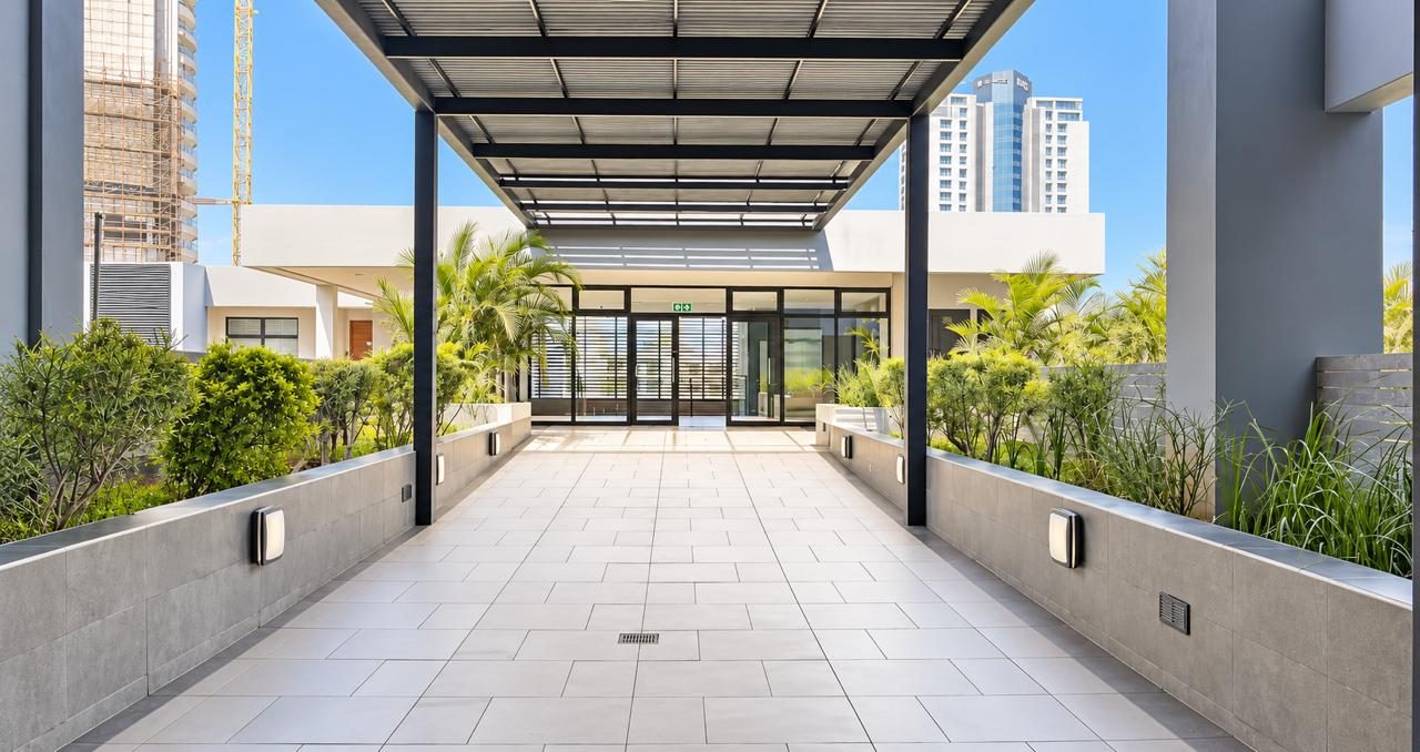 Covered entrance walkway lined with planters