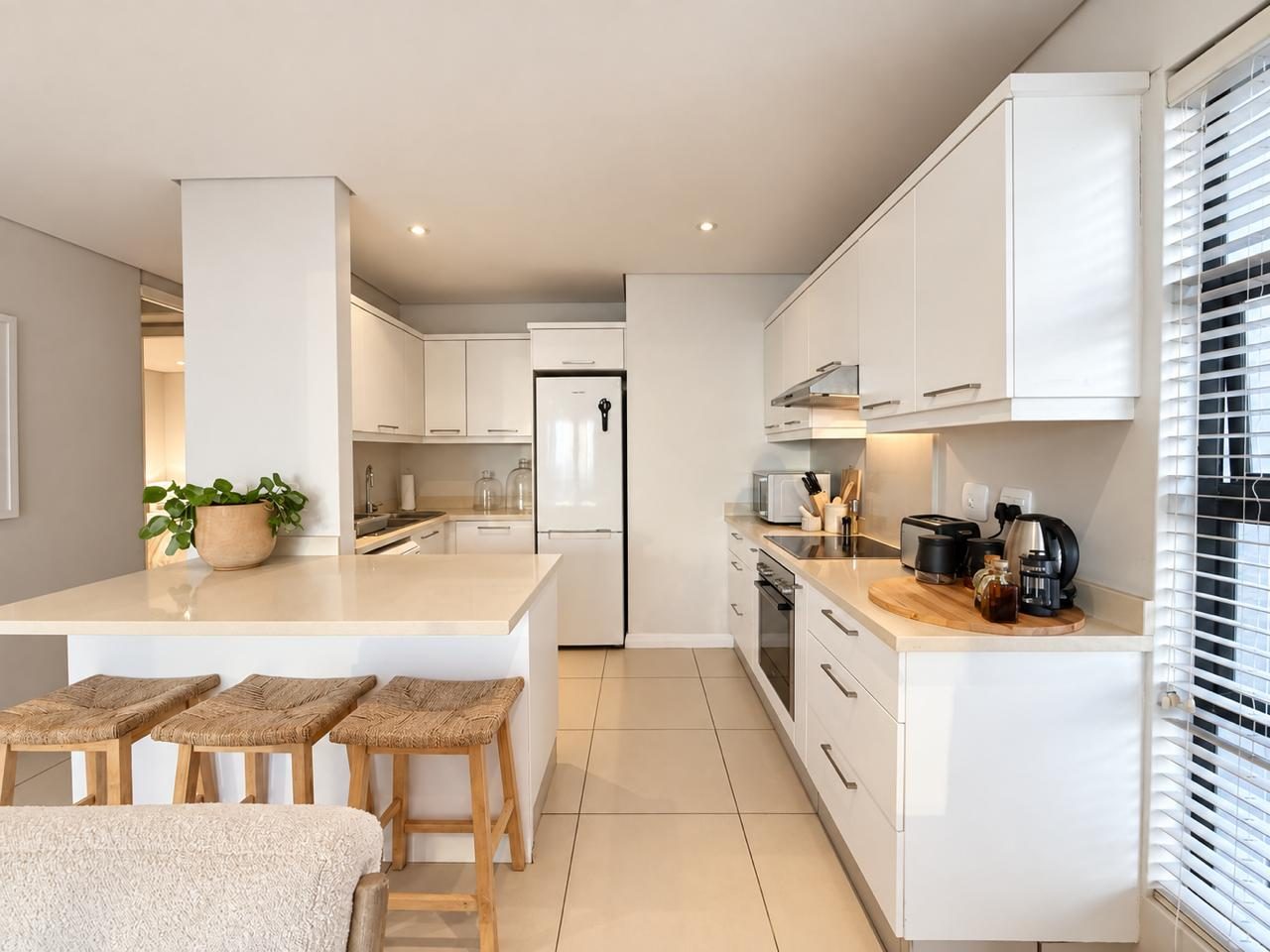 White kitchen with rattan bar stools