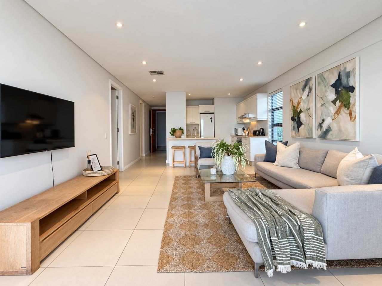 Open-plan Airhost apartment lounge with kitchen beyond