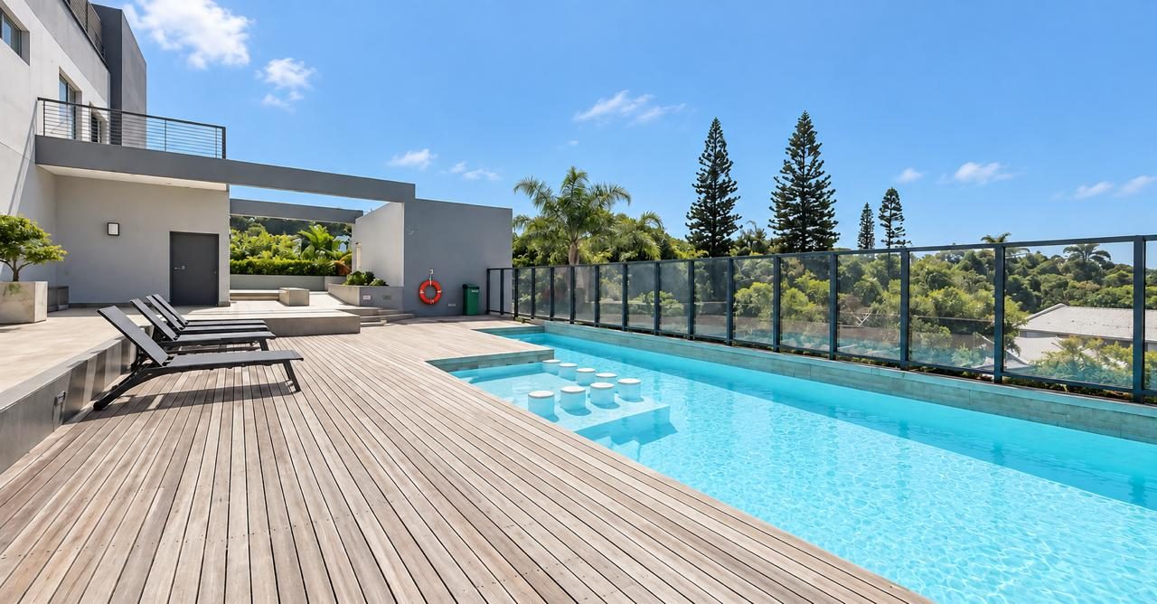 Pool deck with loungers and tropical trees